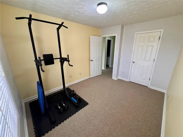 a view of an empty room with a chandelier fan