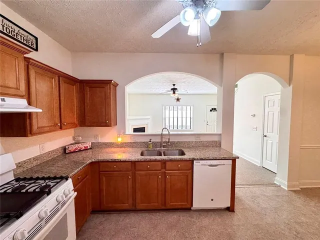 a kitchen with refrigerator a stove a sink dishwasher and a refrigerator with wooden floor