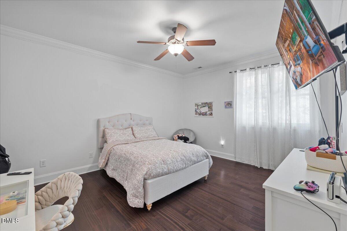 1304 Flying Hawk Road Apex, NC 27523 - Photo 25 of 52 a bedroom with a bed and a chandelier