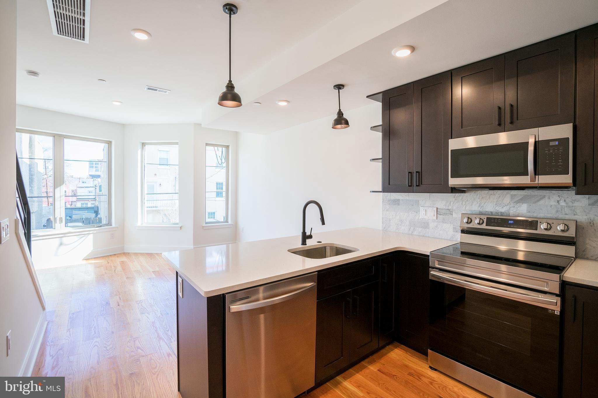 2022 North 5th Street, Unit 2 Philadelphia, PA 19122 - Photo 1 of 23 a kitchen with stainless steel appliances wooden cabinets a stove a sink and dishwasher