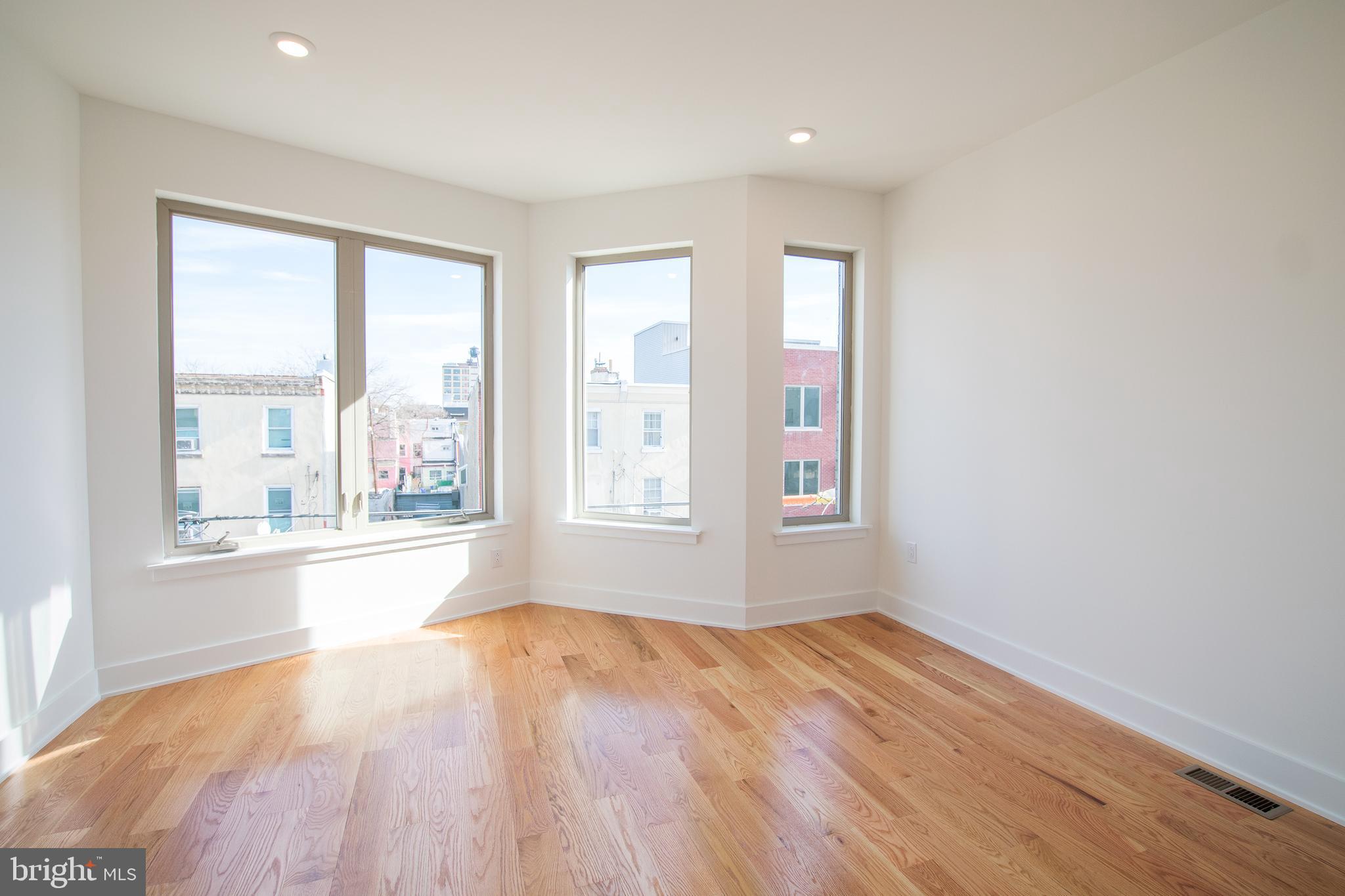 2022 North 5th Street, Unit 2 Philadelphia, PA 19122 - Photo 15 of 23 an empty room with wooden floor and windows