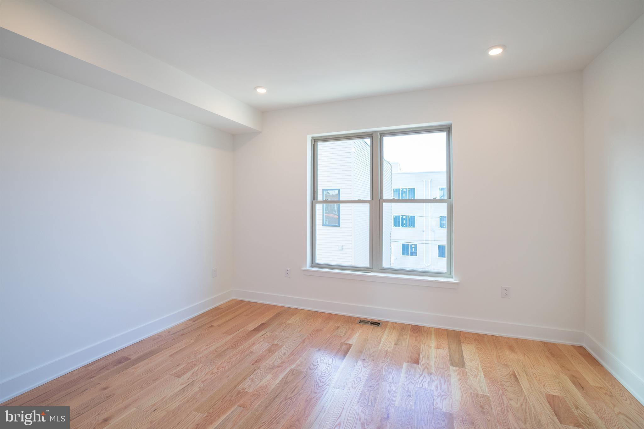 2022 North 5th Street, Unit 2 Philadelphia, PA 19122 - Photo 19 of 23 an empty room with wooden floor and windows