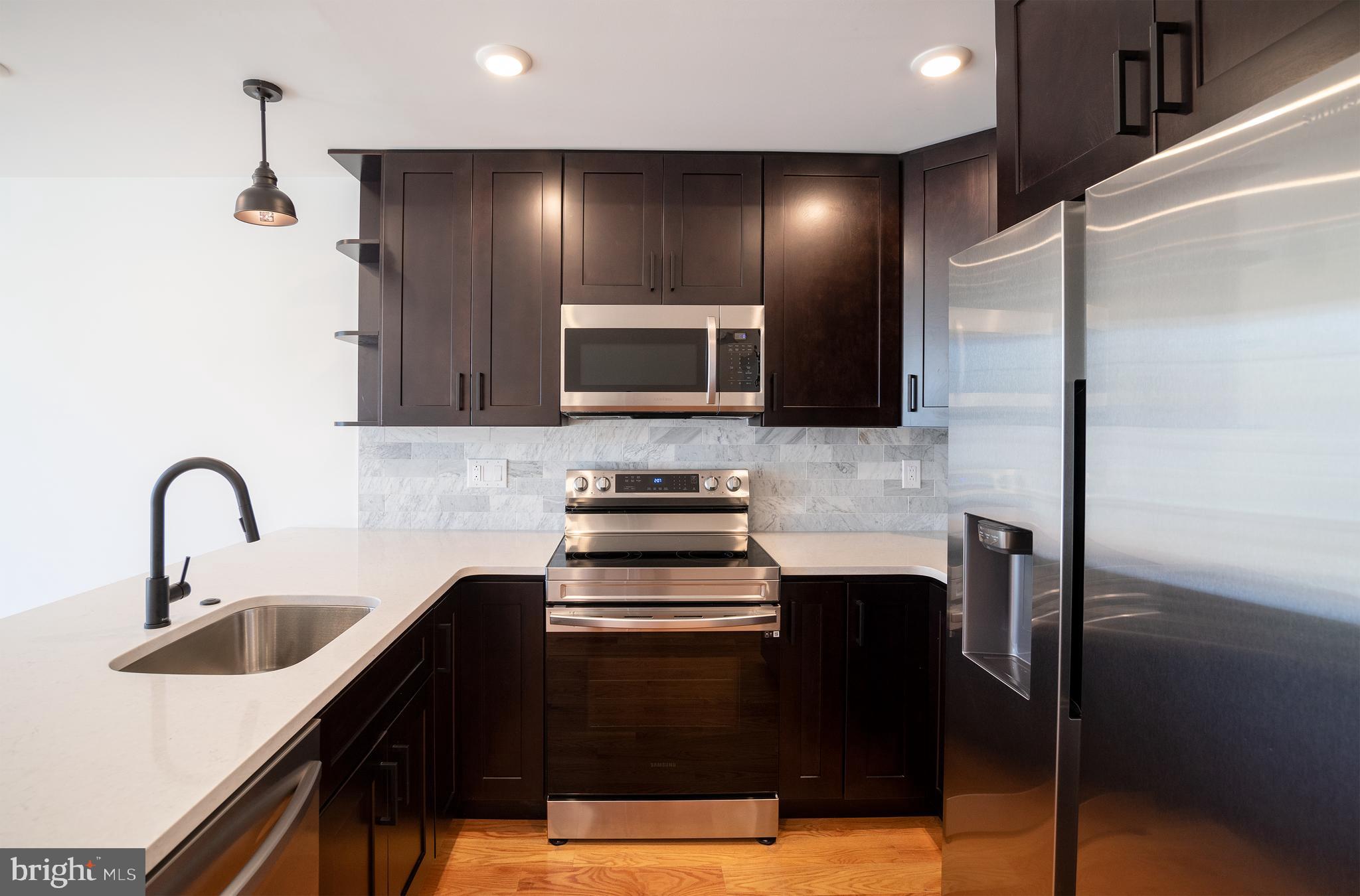 2022 North 5th Street, Unit 2 Philadelphia, PA 19122 - Photo 4 of 23 a kitchen with stainless steel appliances kitchen island granite countertop a refrigerator a sink a stove and cabinets