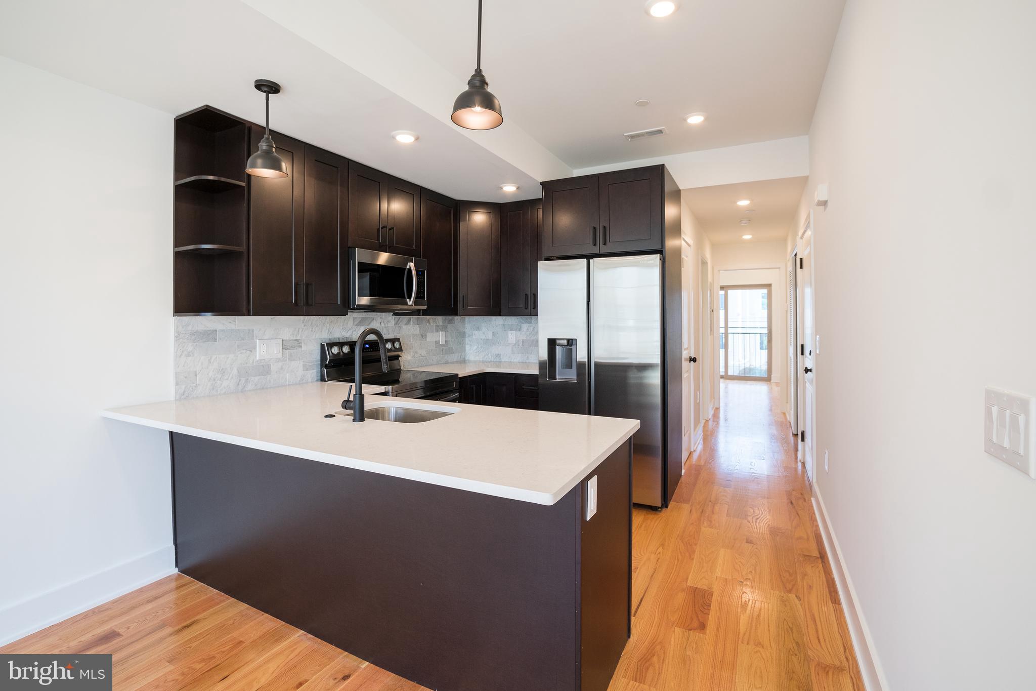2022 North 5th Street, Unit 2 Philadelphia, PA 19122 - Photo 5 of 23 a large white kitchen with a sink a refrigerator and a stove top oven