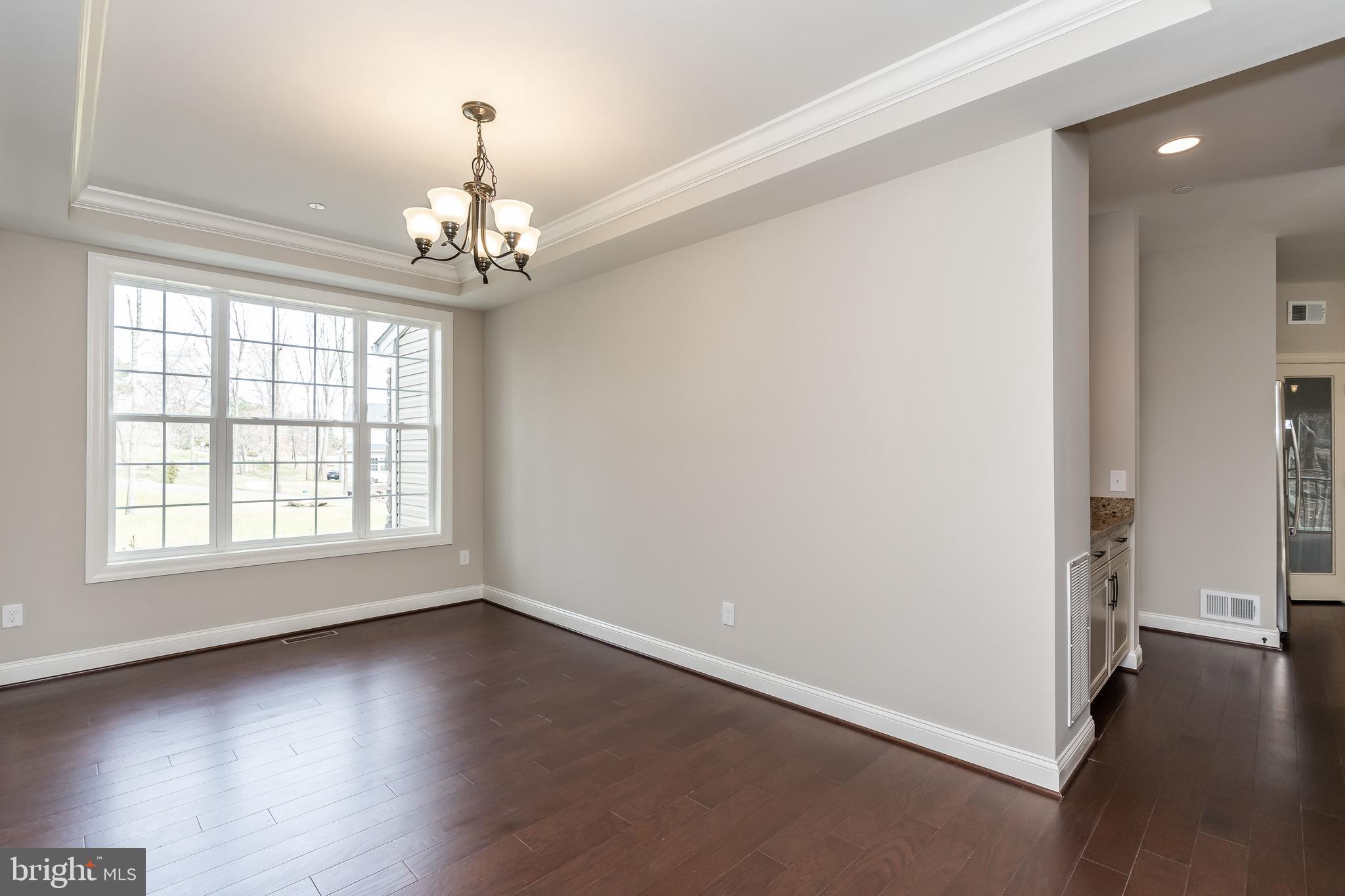 470 Queenstown Road Severn, MD 21144 - Photo 12 of 56 an empty room with wooden floor and windows