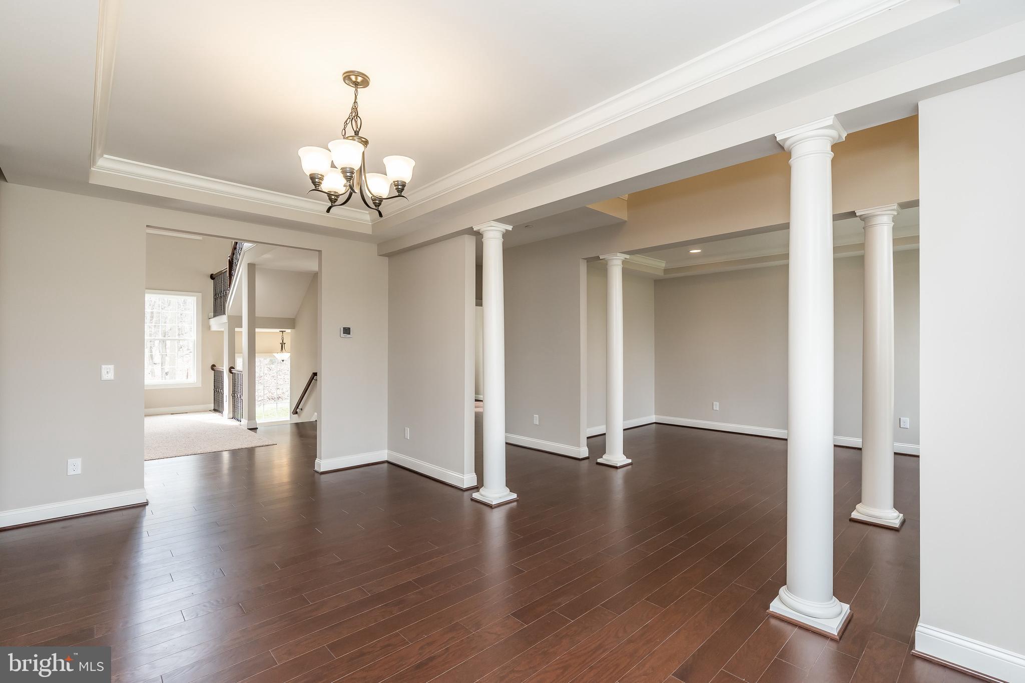 470 Queenstown Road Severn, MD 21144 - Photo 13 of 56 a view of an empty room with wooden floor and a chandelier