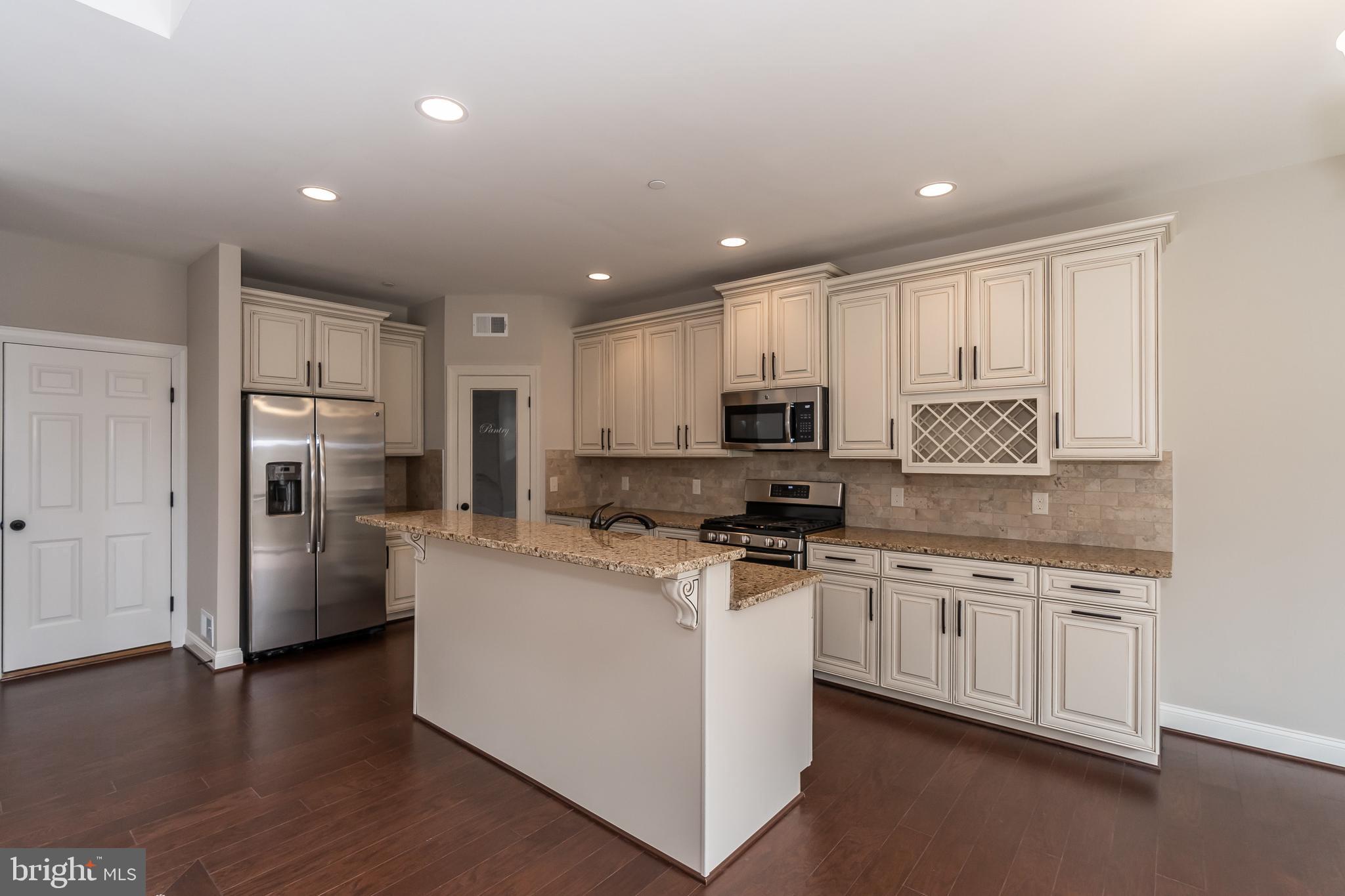 470 Queenstown Road Severn, MD 21144 - Photo 20 of 56 a kitchen with stainless steel appliances granite countertop a stove top oven a refrigerator a sink and dishwasher with wooden floor