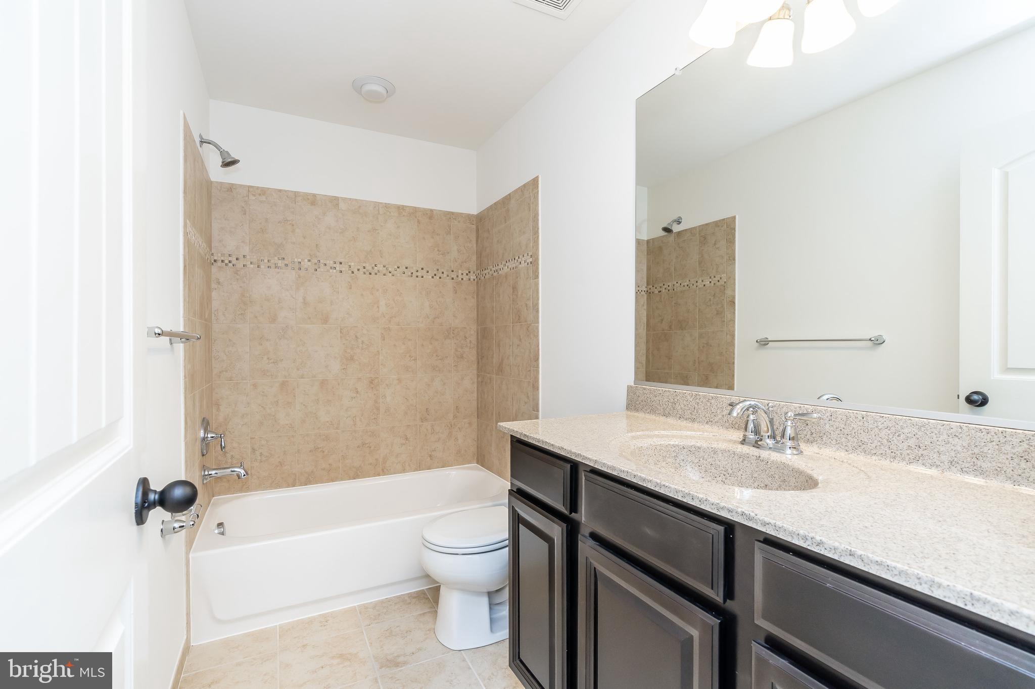 470 Queenstown Road Severn, MD 21144 - Photo 39 of 56 a bathroom with a sink a toilet a mirror and shower
