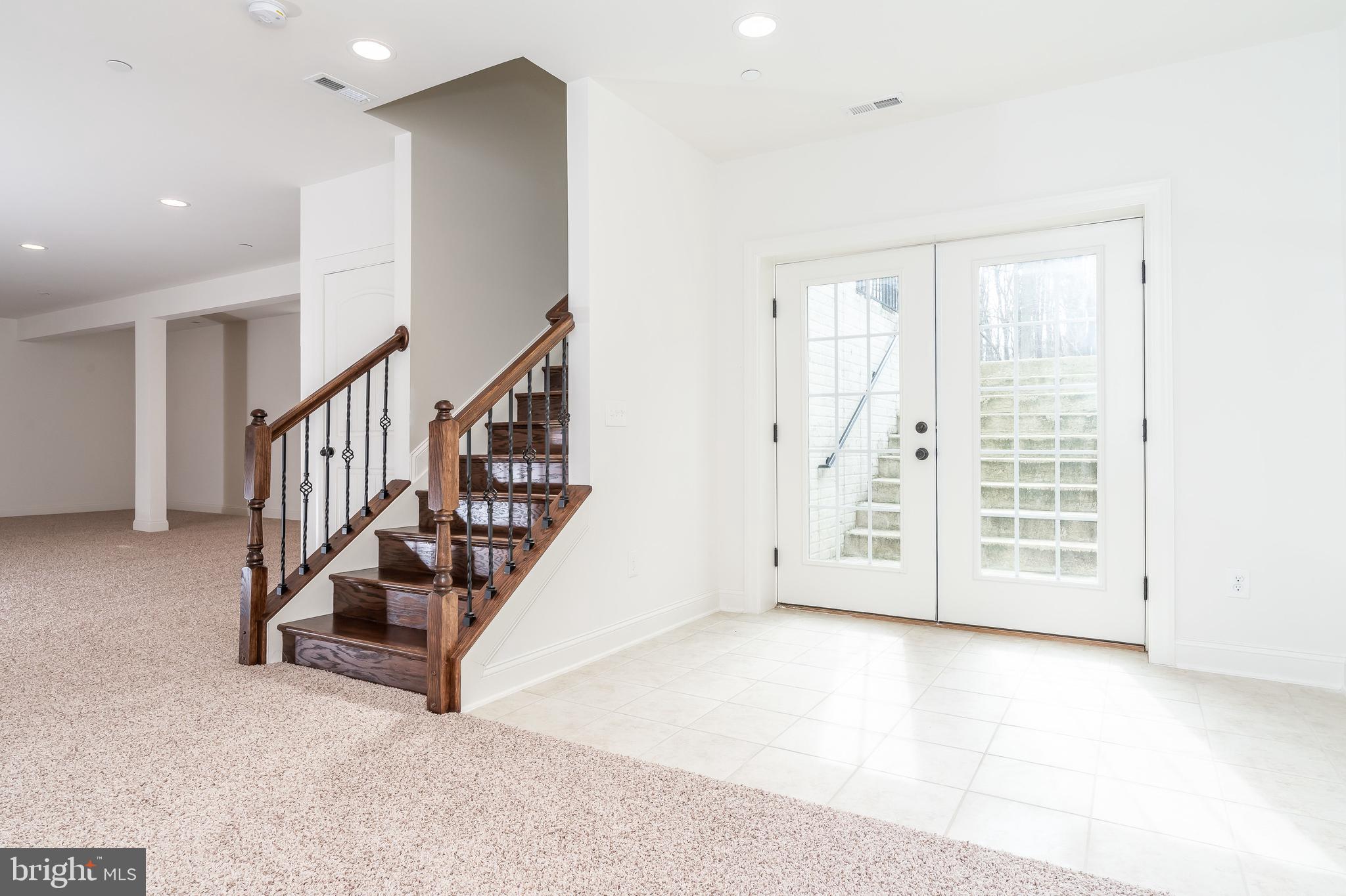 470 Queenstown Road Severn, MD 21144 - Photo 52 of 56 a view of an empty room with wooden floor and stairs
