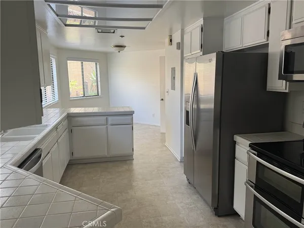 a kitchen with a sink refrigerator and cabinets