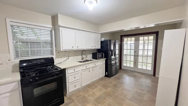 a kitchen with a stove a sink and a window
