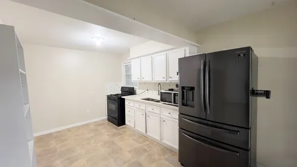 a kitchen with a refrigerator and a stove top oven