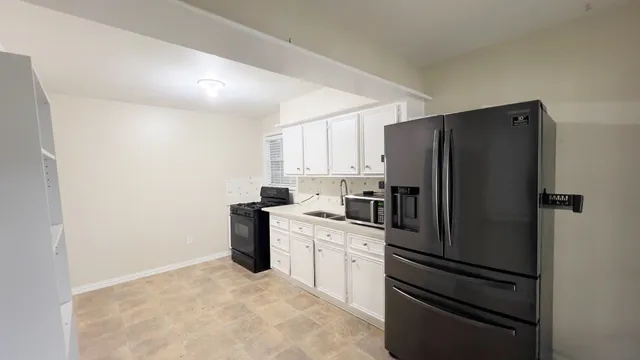 a kitchen with a refrigerator and a stove top oven