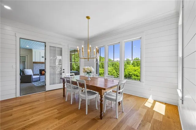 a dining room filled chandelier and wooden floor