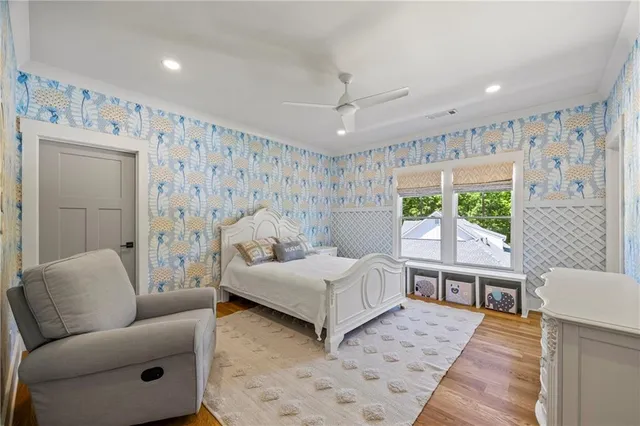 a living room with furniture large windows and wooden floor