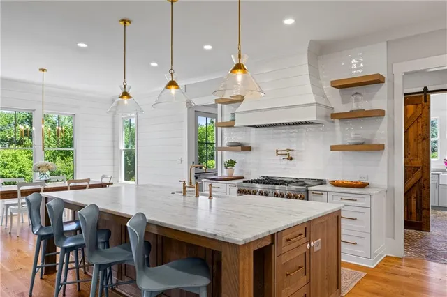 a kitchen with kitchen island a dining table and chairs