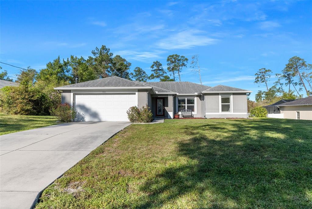 7051 Ovenbird Road Weeki Wachee, FL 34613 - Photo 1 of 1 a front view of a house with a garden