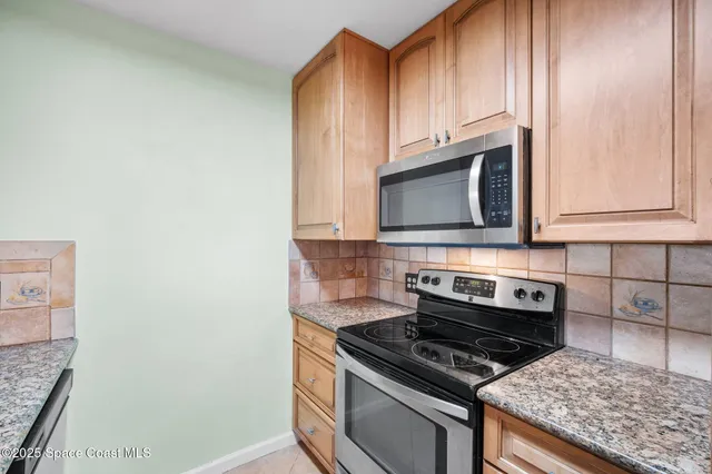 a kitchen with stainless steel appliances granite countertop a stove microwave and sink
