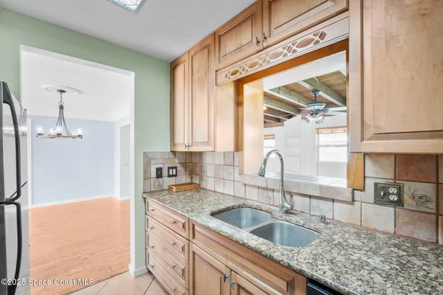 a kitchen with granite countertop a sink a counter top space and cabinets