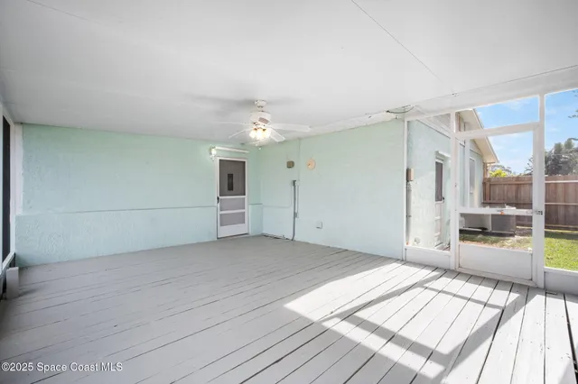 a view of a big room with wooden floor and windows