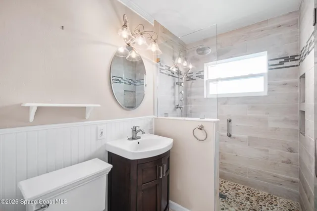 a bathroom with a toilet a sink and mirror