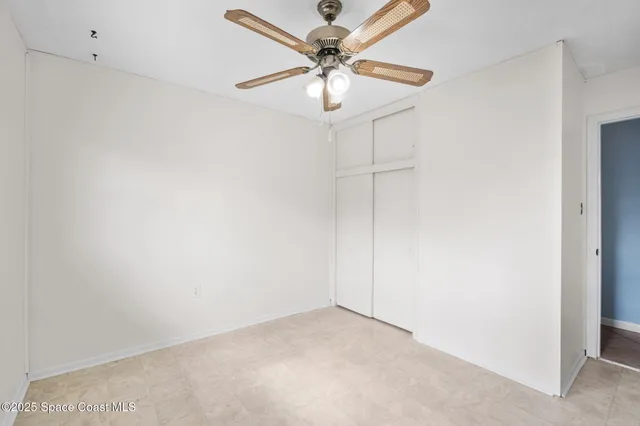 an empty room with a window and a fan