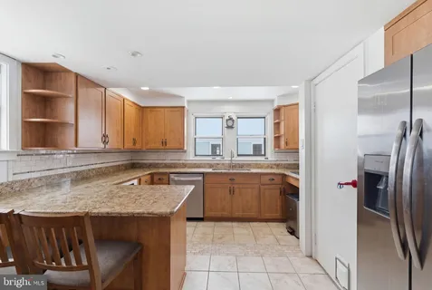 a kitchen with stainless steel appliances granite countertop a sink and a refrigerator
