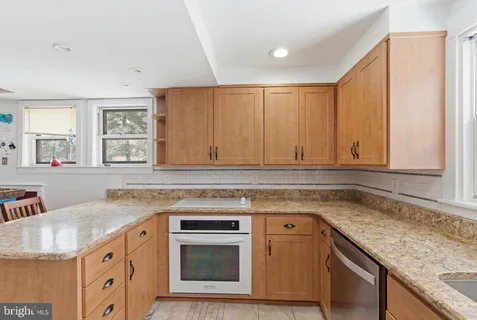 a kitchen with granite countertop a sink stove and cabinets
