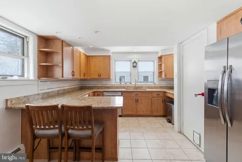 a kitchen with granite countertop a sink stainless steel appliances and cabinets