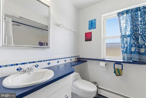 a bathroom with a toilet sink and mirror