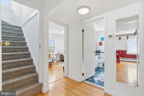 a view of a hallway with white walls and stairs