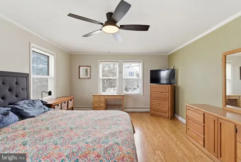 a bedroom with a large bed and a flat tv screen on dresser