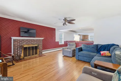 a living room with furniture fireplace and wooden floor