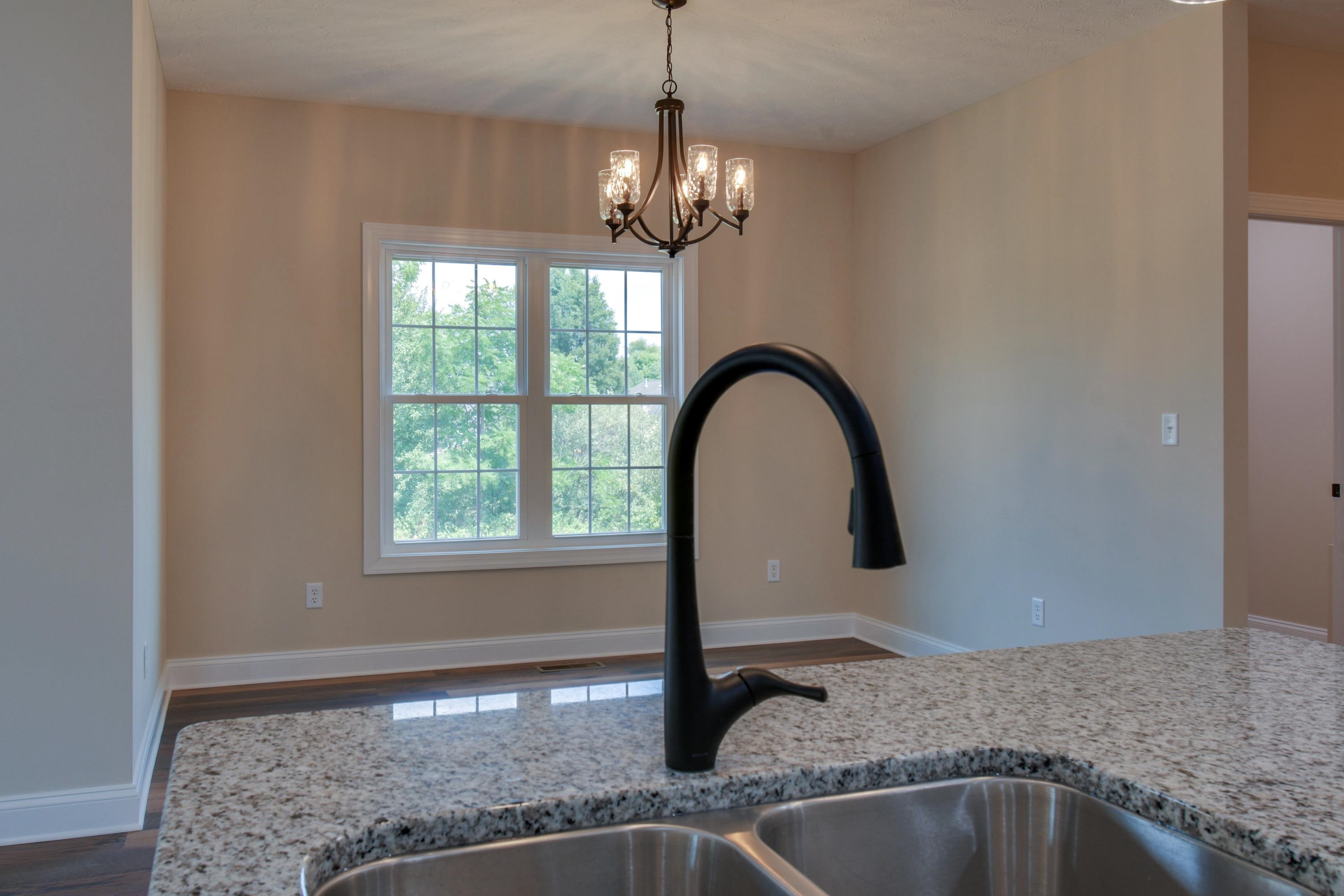 103 Fall Ridge Drive Stuarts Draft, VA 24477 - Photo 13 of 31 a kitchen with a faucet a chandelier and fireplace