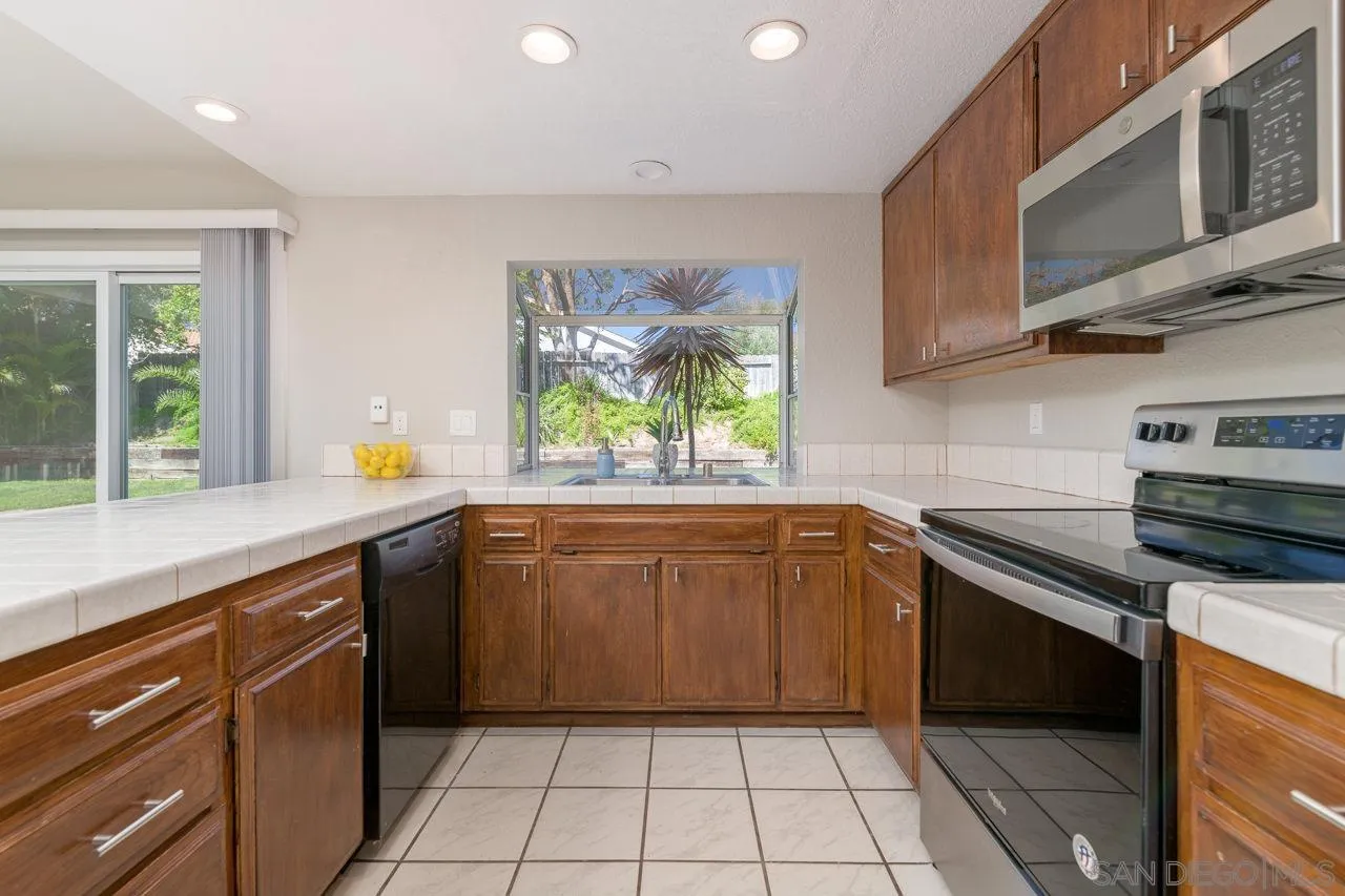 1908 Hummock Lane Encinitas, CA 92024 - Photo 15 of 29 a kitchen with stainless steel appliances granite countertop a stove a sink and a microwave