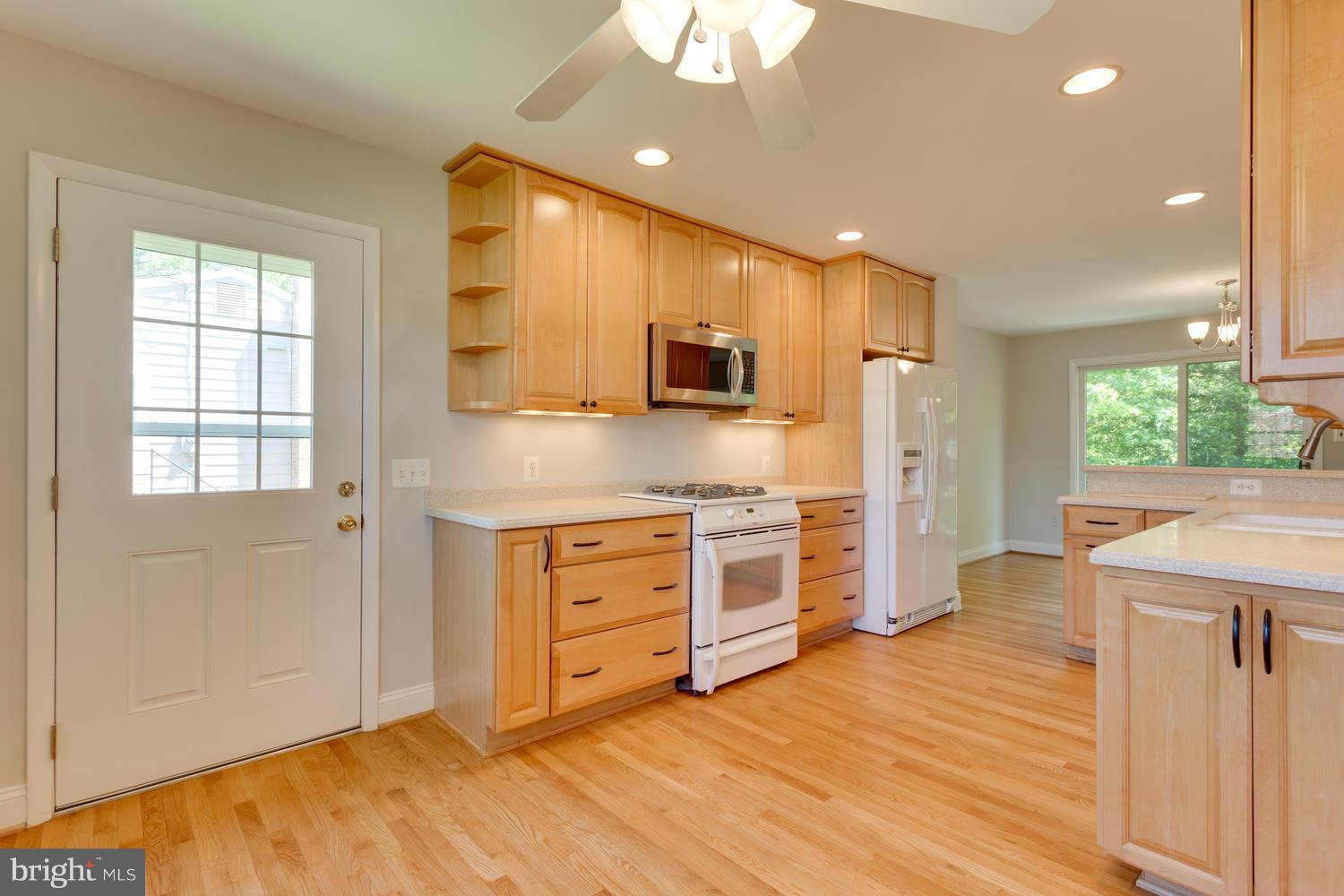 6003 Meriwether Lane Springfield, VA 22150 - Photo 11 of 30 a kitchen with stainless steel appliances kitchen island granite countertop a stove a sink and a refrigerator