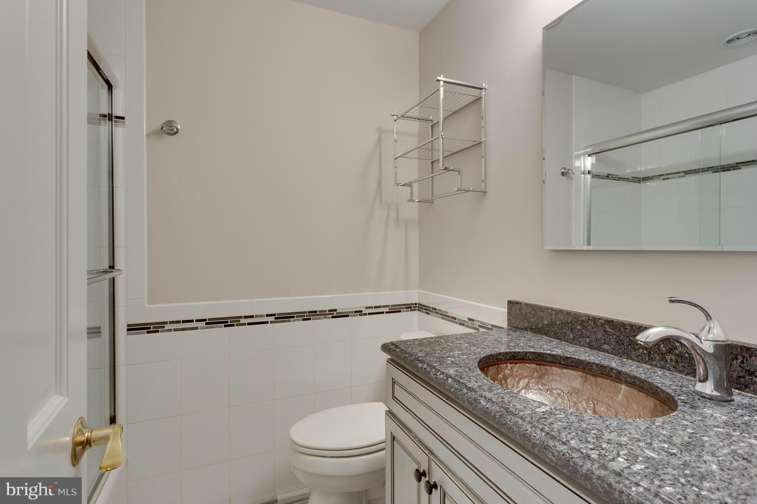 6003 Meriwether Lane Springfield, VA 22150 - Photo 22 of 30 a bathroom with a granite countertop sink a toilet and shower