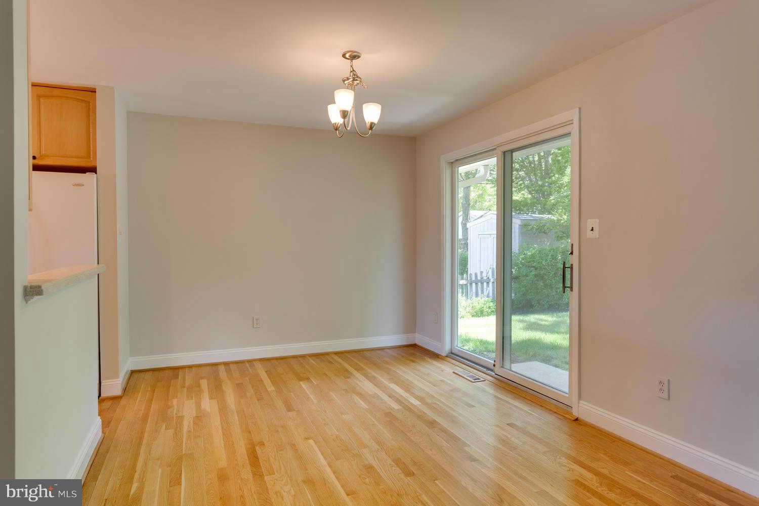 6003 Meriwether Lane Springfield, VA 22150 - Photo 6 of 30 a view of an empty room with wooden floor and a window