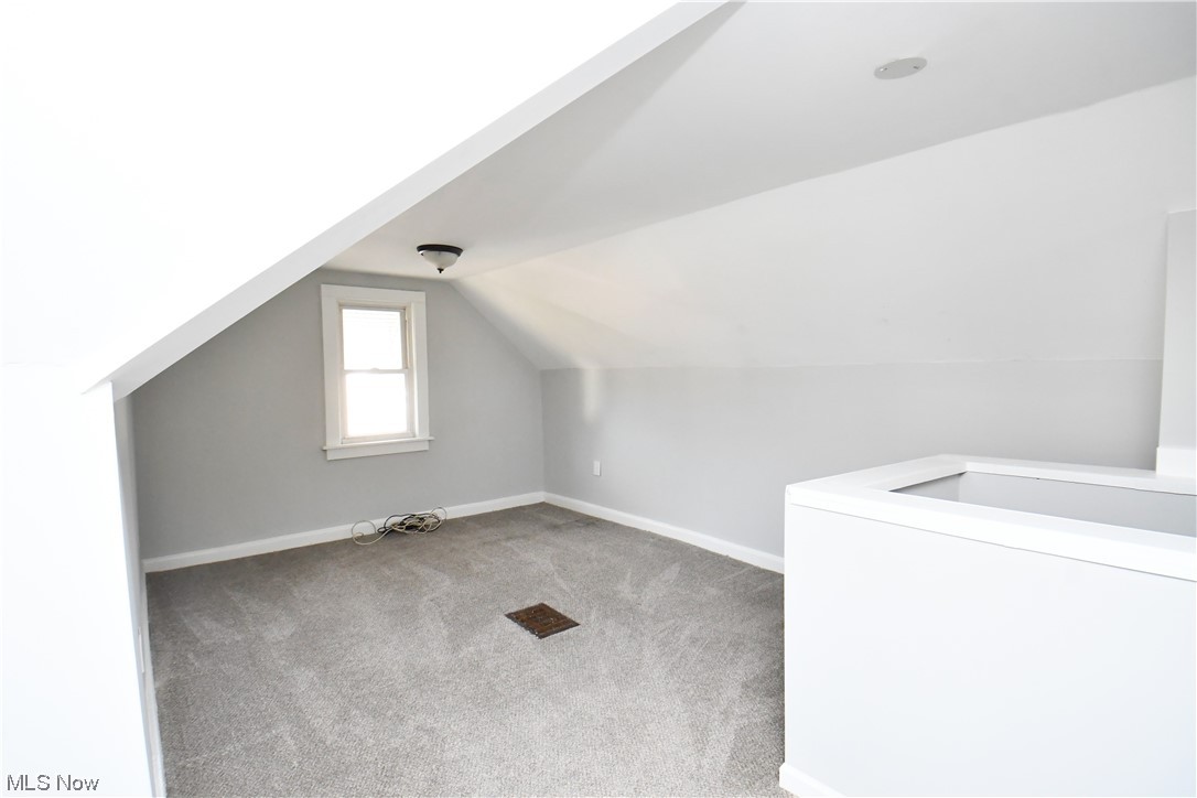 3193 Joslyn Road Cleveland, OH 44111 - Photo 35 of 41 Additional living space with vaulted ceiling, washer / clothes dryer, and carpet flooring