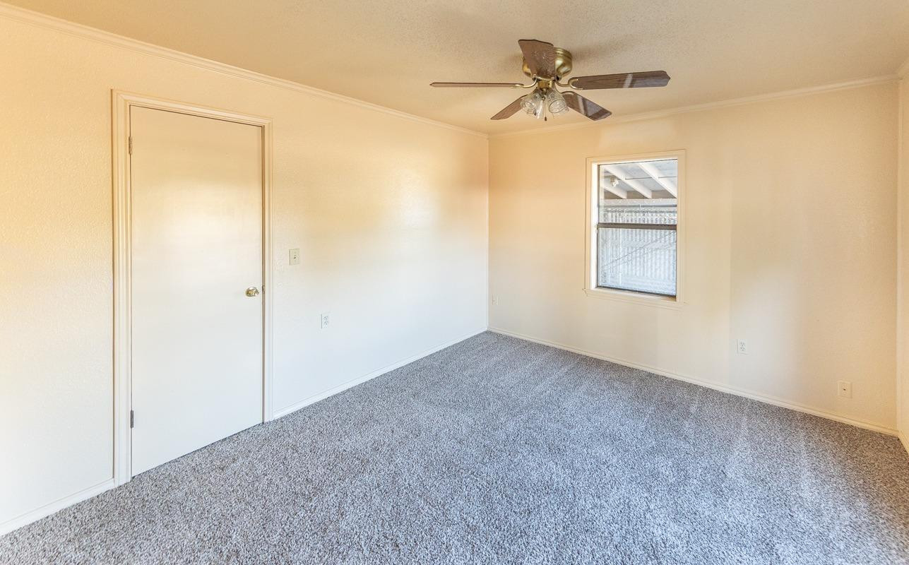 3007 Emory Street Lubbock, TX 79415 - Photo 11 of 17 an empty room with a window and a fan