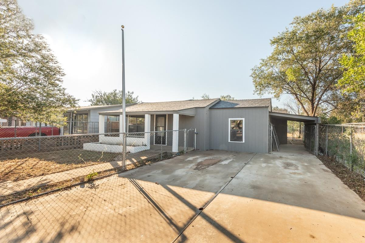 3007 Emory Street Lubbock, TX 79415 - Photo 16 of 17 a front view of a house with a yard and potted plants