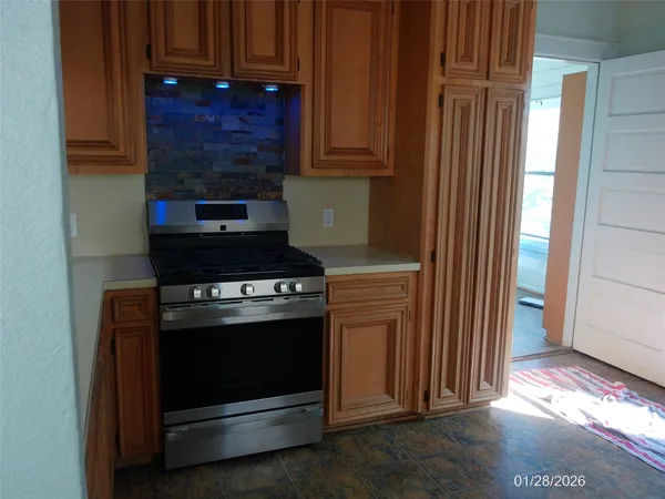 a view of an empty room with a fireplace and a window