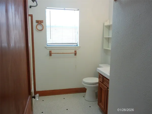 a bathroom with a toilet and a window