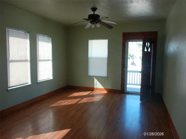 a view of a kitchen with a fridge and wooden floor