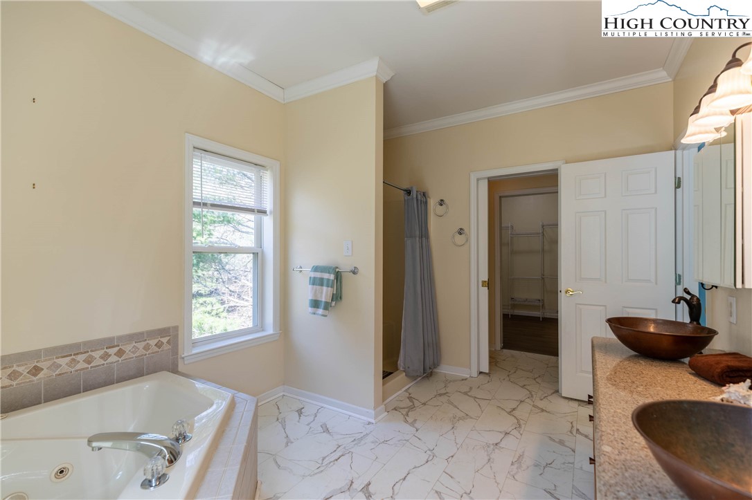449 Meadow Ridge Drive Jefferson, NC 28640 - Photo 15 of 37 a bathroom with a tub sink and a mirror