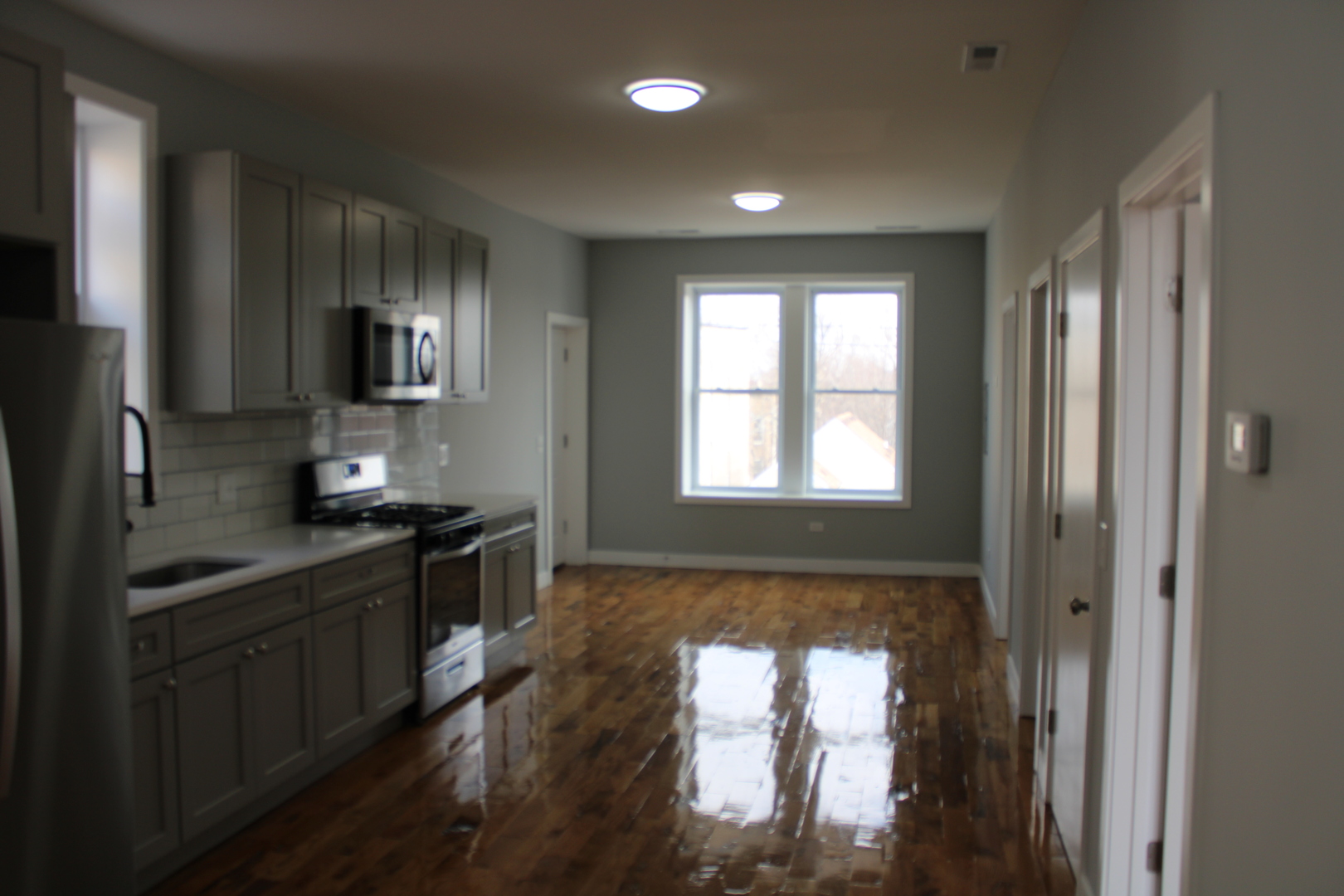 1533 South Ridgeway Avenue, Unit 1R Chicago, IL 60623 - Photo 2 of 7 a kitchen with stainless steel appliances granite countertop a stove a sink and a refrigerator