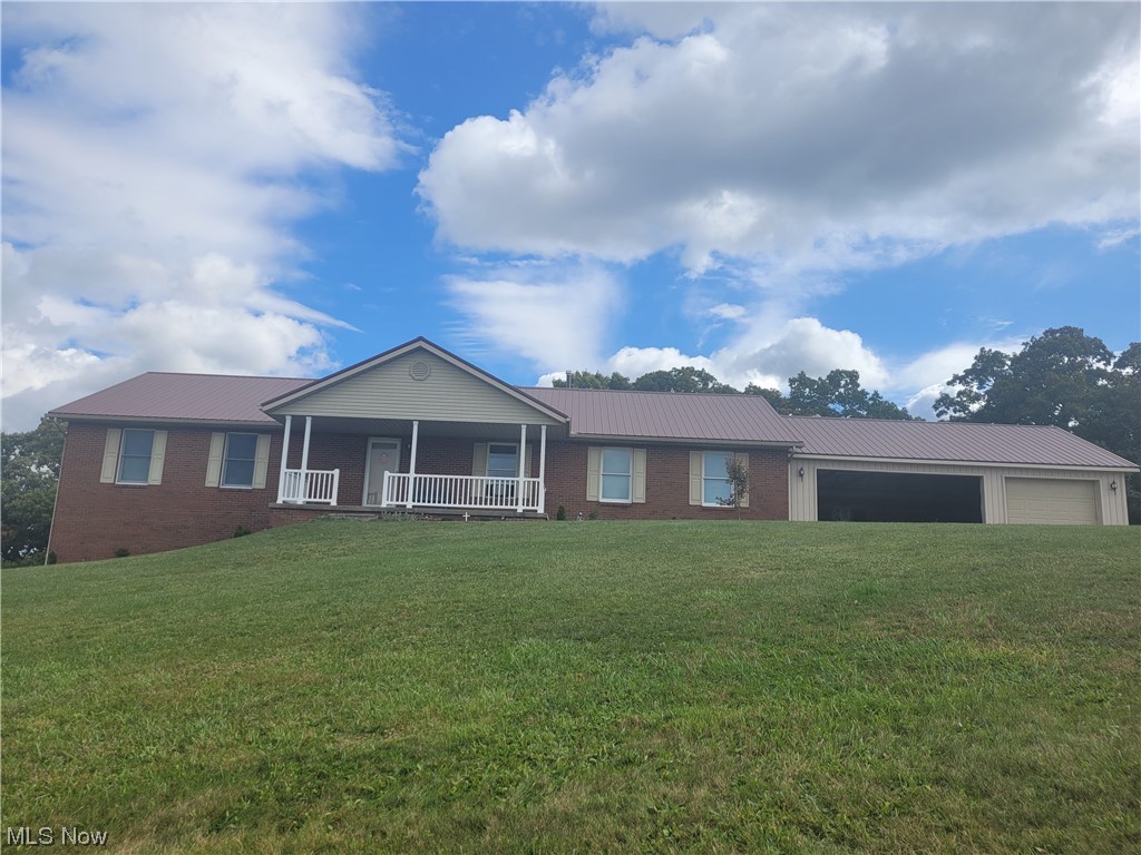 Single story home with a front lawn, a garage, and covered porch