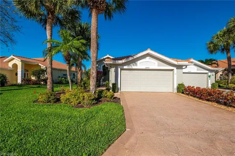 a front view of a house with a garden and yard