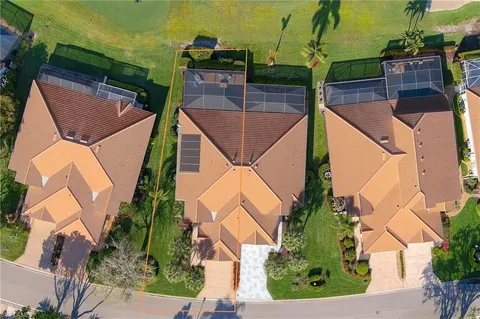 an aerial view of residential houses with outdoor space and trees