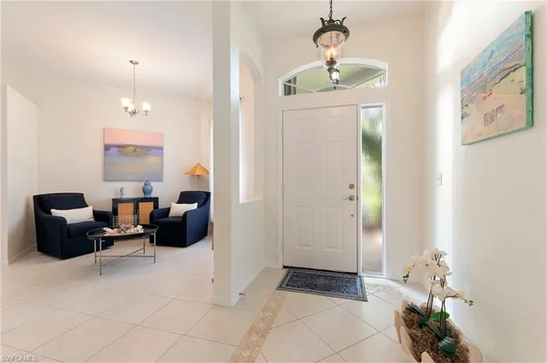 a living room with furniture and a chandelier